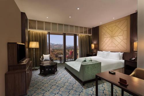 a hotel room with a bed and a television at ITC Kohenur, a Luxury Collection Hotel, Hyderabad in Hyderabad