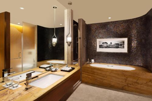 ein Badezimmer mit einer großen Badewanne und einem Waschbecken in der Unterkunft ITC Kohenur, a Luxury Collection Hotel, Hyderabad in Hyderabad