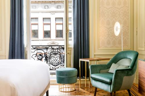 - une chambre avec une chaise verte et une fenêtre dans l'établissement Sapphire House Antwerp, Autograph Collection, à Anvers
