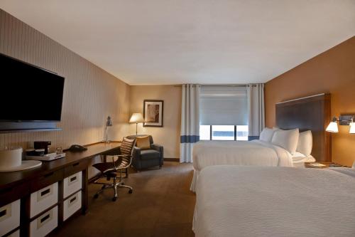 a hotel room with two beds and a desk at Four Points by Sheraton Peoria in Peoria