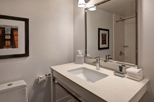 a white bathroom with a sink and a mirror at Four Points by Sheraton Peoria in Peoria