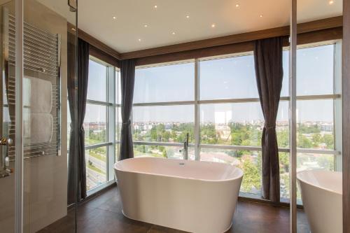 a bathroom with two tubs in front of a large window at Sheraton Novi Sad in Novi Sad