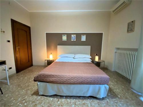 a bedroom with a large bed and two lamps on tables at Casa Viola a 900 mt dalla Staz. Centrale in Pescara