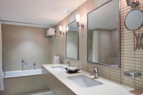 a bathroom with two sinks and a mirror and a tub at Sheraton Djibouti in Djibouti