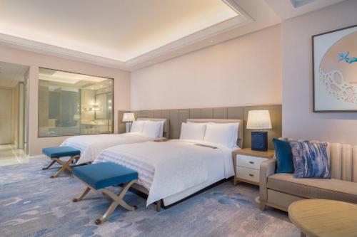 a hotel room with two beds and a couch at Le Meridien Suzhou, Suzhou Bay in Suzhou