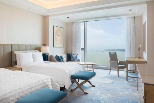 a hotel room with two beds and a large window at Le Meridien Suzhou, Suzhou Bay in Suzhou