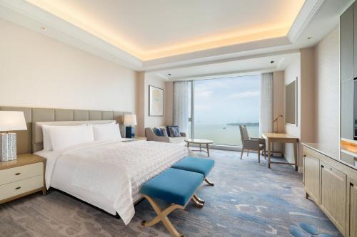 a hotel room with a bed and a large window at Le Meridien Suzhou, Suzhou Bay in Suzhou