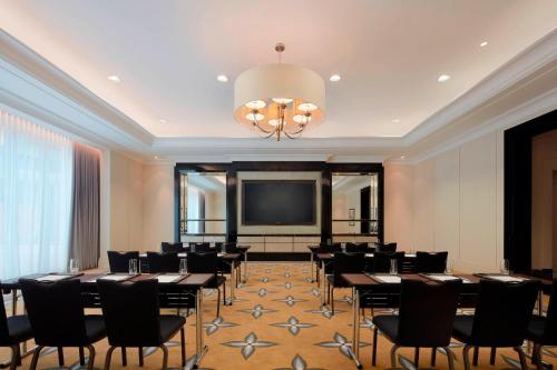 a conference room with tables and chairs and a flat screen tv at The St. Regis Kuala Lumpur in Kuala Lumpur