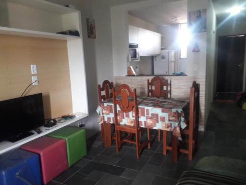 a kitchen with a table and chairs in a room at AP DA FABY in Barra de São Miguel