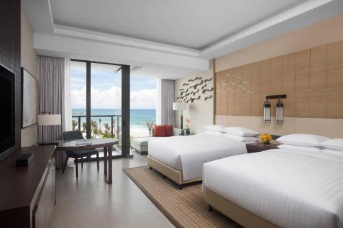 a hotel room with two beds and a view of the ocean at Marriott Resort Xiangshui Bay in Lingshui