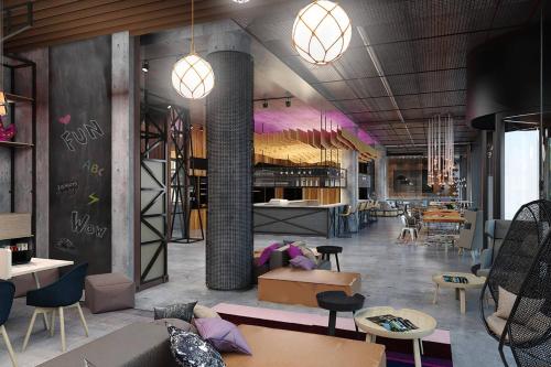 a room with tables and chairs and aasteryasteryasteryasteryasteryasteryasteryastery at Moxy Szczecin City in Szczecin
