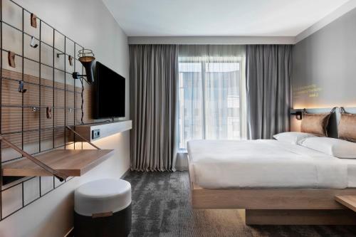 een hotelkamer met een bed en een groot raam bij Moxy Szczecin City in Szczecin