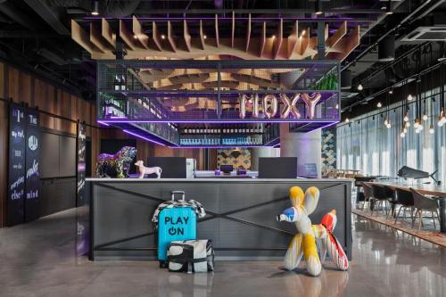 a restaurant with a lobby with a payon sign on the counter at Moxy Szczecin City in Szczecin