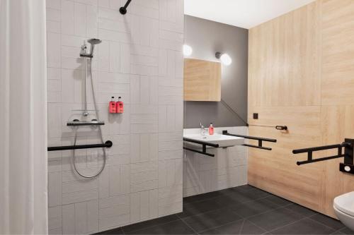 a bathroom with a shower and a sink at Moxy Szczecin City in Szczecin