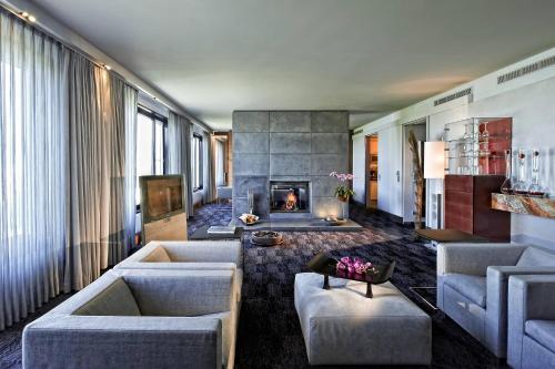 a living room with two couches and a fireplace at Sheraton Berlin Grand Hotel Esplanade in Berlin