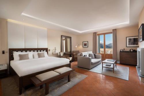 a bedroom with a bed and a living room at Renaissance Tuscany Il Ciocco Resort & Spa in Barga