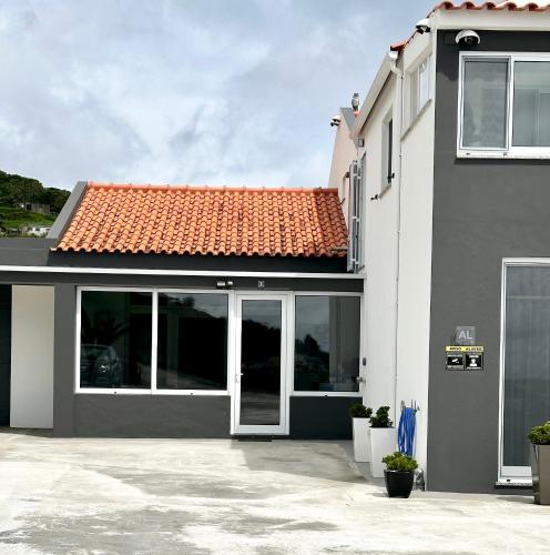 a house with a red tile roof at Paradise Apartments I in Santa Cruz das Flores