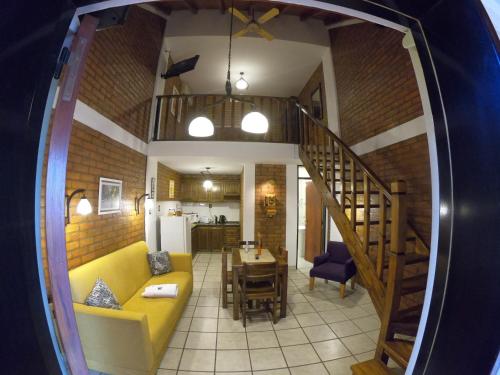 a living room with a yellow couch and a kitchen at El Paso departamentos in San Juan