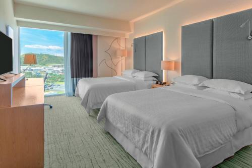 a hotel room with two beds and a flat screen tv at Sheraton San Jose Hotel, Costa Rica in San José