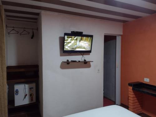 Habitación con TV en la pared y cama en Pousada Alto das Galés, en Maragogi