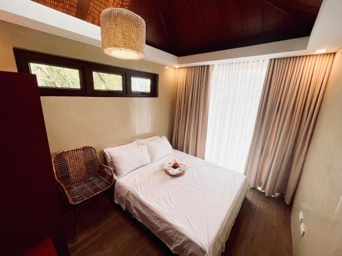 niewielka sypialnia z łóżkiem i oknem w obiekcie Casa Talia Beach House w mieście Lobo