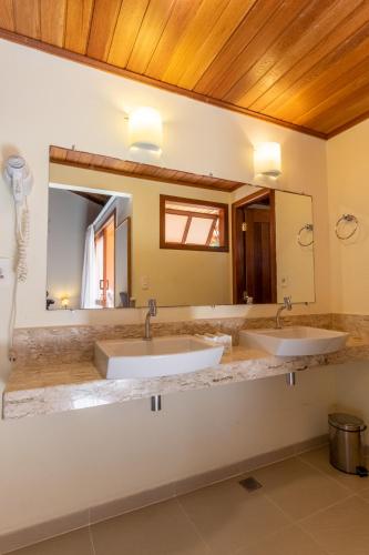 a bathroom with two sinks and a mirror at Club do Balanço Pousada e Restaurante in Morro de São Paulo