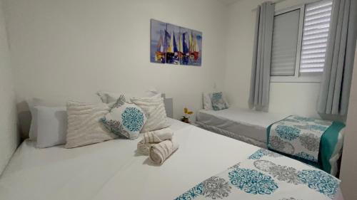 a bedroom with two beds and a window at Portal das Palmeiras 2 in Ubatuba