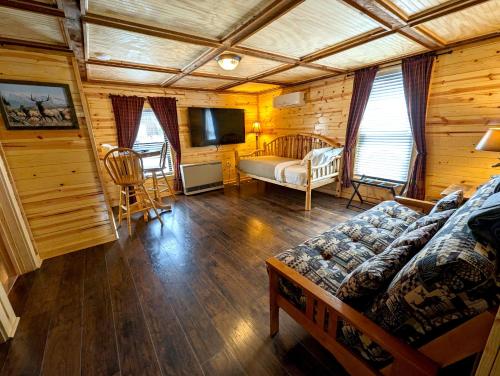 a living room with a couch and a tv in a cabin at Yellowstone Treasure Guesthouses on the River in Gardiner