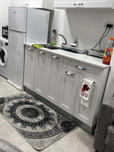 a white kitchen with a sink and a refrigerator at דירה מדהימה קטנטנה תאהבו אותה ، A small, beautiful and comfortable apartment, you will love in Haifa