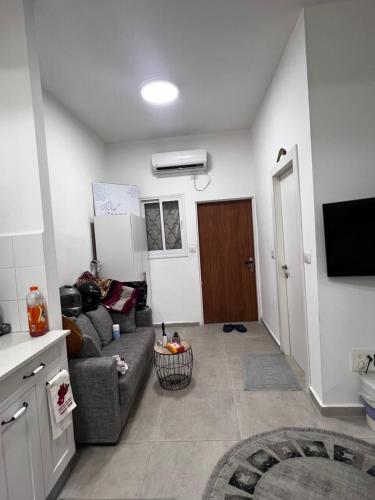 a living room with a couch and a tv at דירה מדהימה קטנטנה תאהבו אותה ، A small, beautiful and comfortable apartment, you will love in Haifa