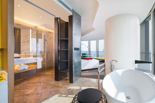 a bathroom with a white tub and a sink at W Shanghai - The Bund in Shanghai