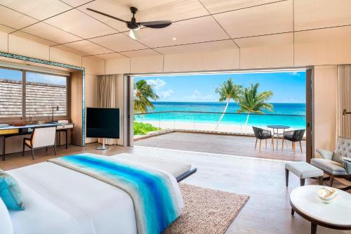The St. Regis Maldives Vommuli Resort في دالو أتول: غرفة نوم مع سرير وإطلالة على المحيط