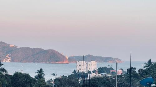 a view of a city and the ocean with mountains at Cómodo y muy relajante alojamiento a 5 minutos de la playa in Acapulco
