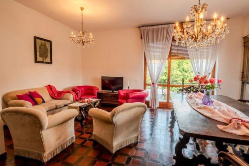 a living room with a couch and a table and a chandelier at Villa Gabri in Arona