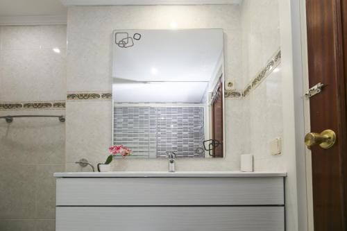 ein Bad mit einem Waschbecken und einem Spiegel in der Unterkunft Adrian Planetcostadorada in La Pineda