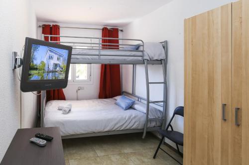 Kleines Zimmer mit einem Etagenbett und einem TV. in der Unterkunft Adrian Planetcostadorada in La Pineda