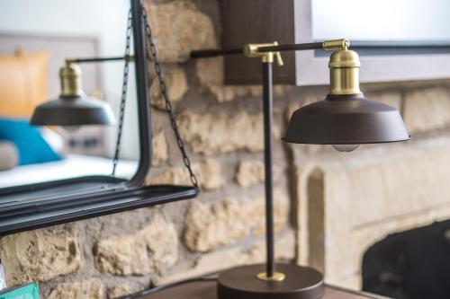 a black lamp sitting on a table in front of a fireplace at Abbey Hotel Bath, a Tribute Portfolio Hotel in Bath