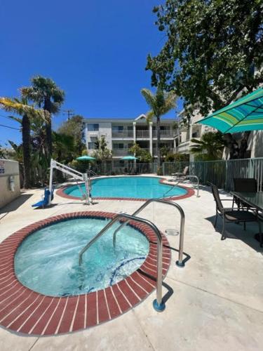 a large swimming pool with a table and umbrella at Hotel Buena Vista - San Luis Obispo in San Luis Obispo