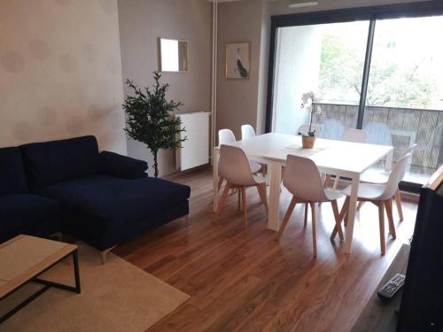 a living room with a white table and a blue couch at L'Escale - appartement spacieux au calme in Brest