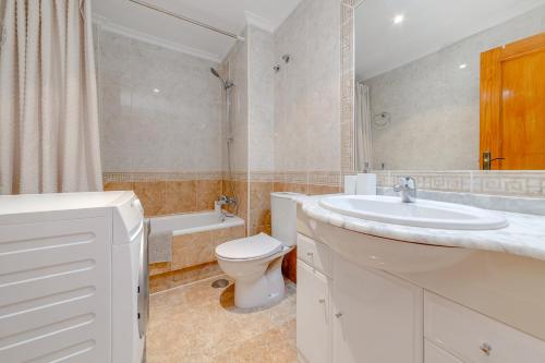 a white bathroom with a sink and a toilet at Penthouse Naomi with two terraces, private solarium, sea view, swimming pool, with underground parking, pets allowed in Orihuela Costa