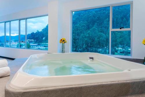 a large bath tub in a room with windows at Four Points by Sheraton Cuenca in Cuenca