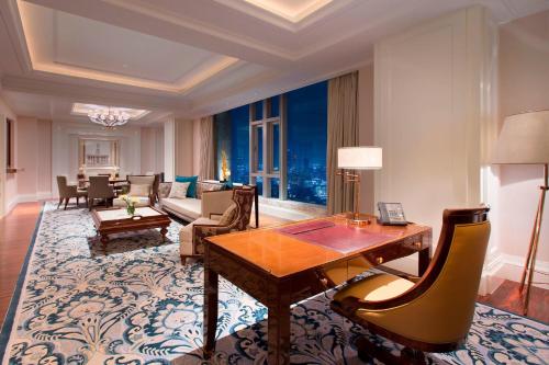 a living room with a table and a couch at Sheraton Grand Wuhan Hankou Hotel in Wuhan