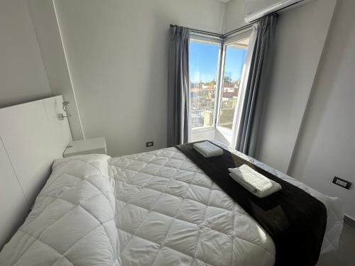 a bedroom with a bed and a large window at DOMUM 144 in San Juan