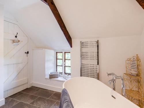 baño blanco con lavabo y ventana en The Bing en Buckland in the Moor