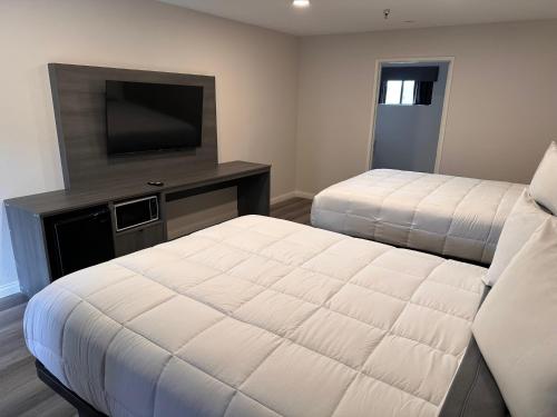 a bedroom with two beds and a television at Five Star Inn in West Covina