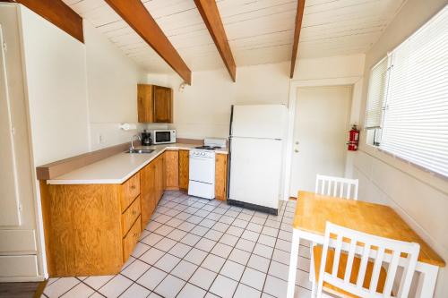 a kitchen with a white refrigerator and a table at Redwood Meadows RV Resort in Crescent City