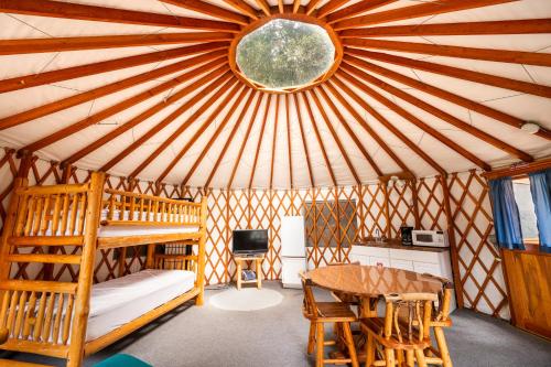 Una habitación con una yurta con una cama y una mesa en Redwood Meadows RV Resort, en Crescent City