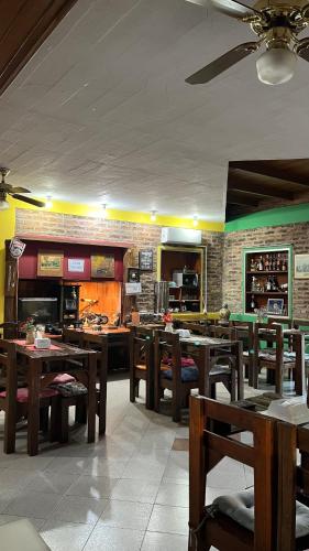 a restaurant with wooden tables and chairs and a bar at Hotel Village Termas de Dayman in Termas del Daymán