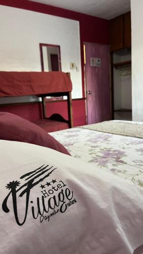 a white bed with a sign on top of it at Hotel Village Termas de Dayman in Termas del Daymán