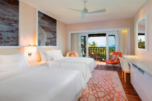 a hotel room with two beds and a balcony at The Westin Langkawi Resort & Spa in Kuah